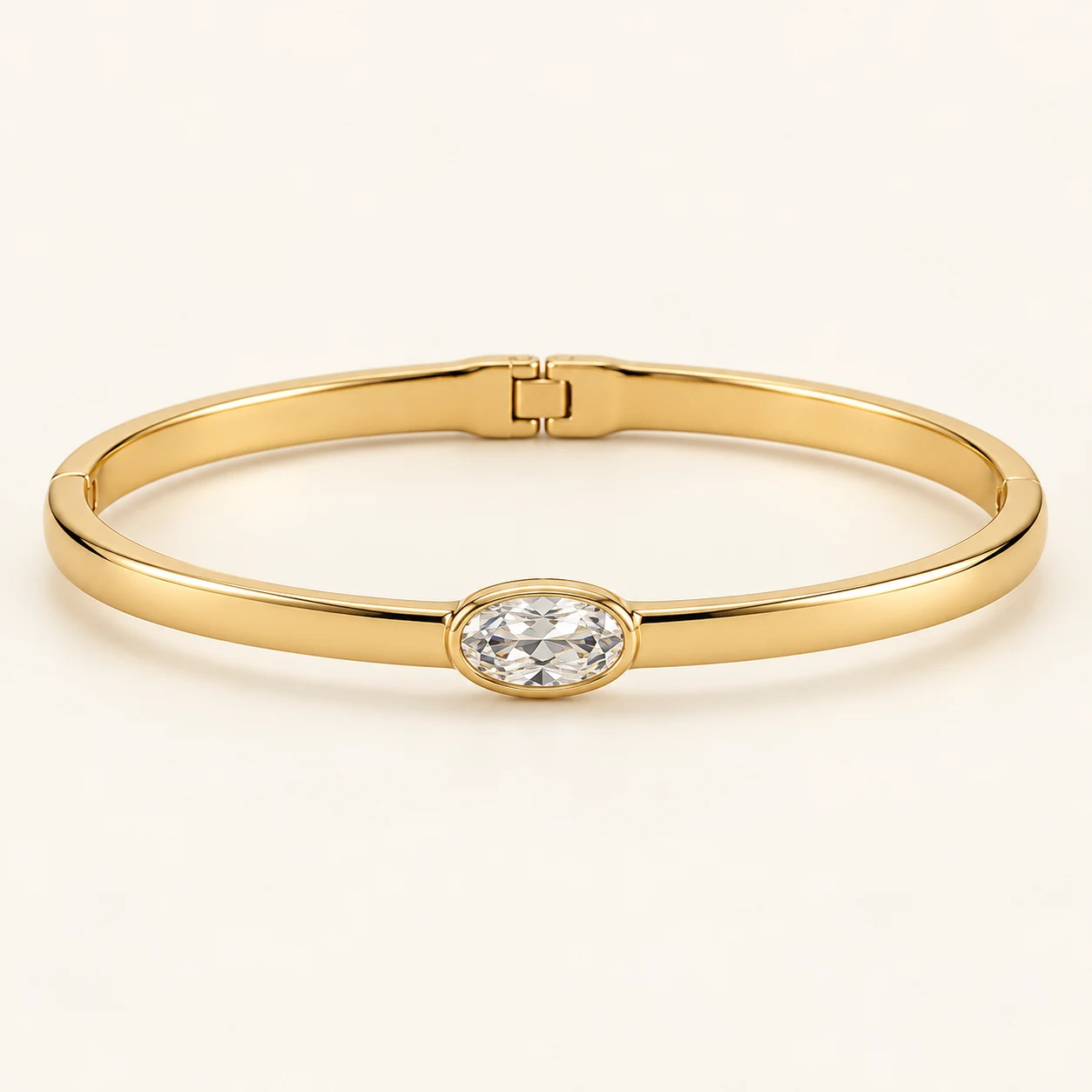 Aurelle Oval in Gold, slim hinged oval rigid bangle, one central oval clear cubic zirconia set horizontally, otherwise plain smooth band
